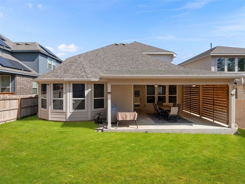 Back of house featuring a fenced backyard, a patio, and roof with shingles