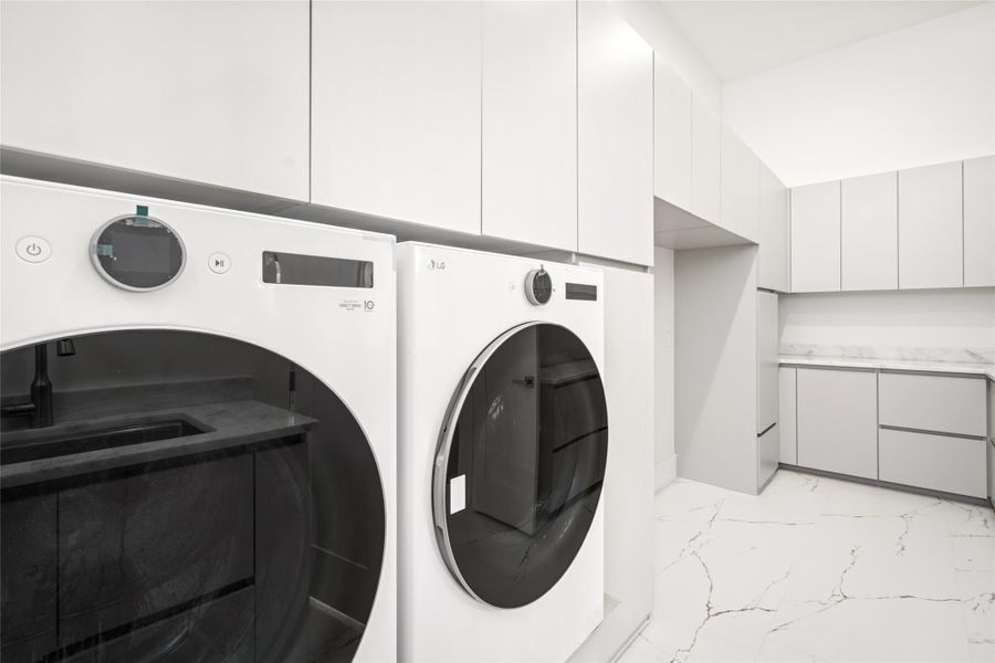 The spacious utility room is both stylish and highly functional, featuring an abundance of built-in cabinets and drawers, ample counter space for folding, and an LG washer and dryer. Thoughtfully designed, it also offers room for two additional refrigerators or freezers—ideal for flexible storage needs. The spacious utility room is both stylish and highly functional, featuring an abundance of built-in cabinets and drawers, ample counter space for folding, and an LG washer and dryer. Thoughtfully designed, it also offers room for two additional refrigerators or freezers—ideal for flexible storage needs.