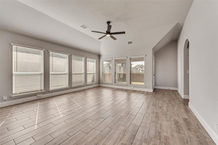 Empty room featuring wood tiled floors, a ceiling fan, vaulted ceiling, and arched walkways Empty room featuring wood tiled floors, a ceiling fan, vaulted ceiling, and arched walkways