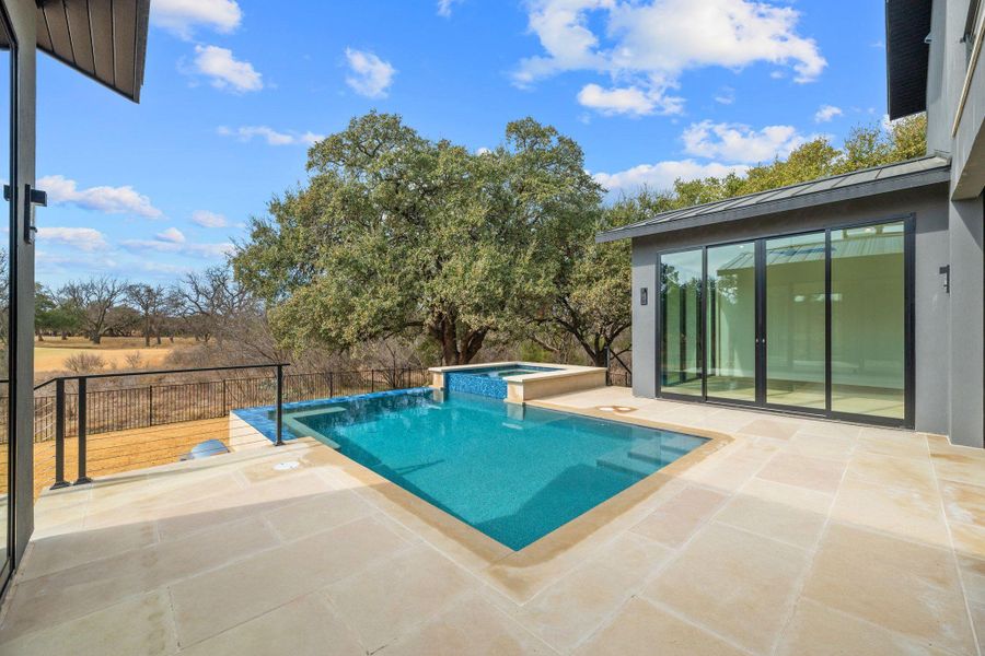 Integrated pool / hot tub featuring a patio