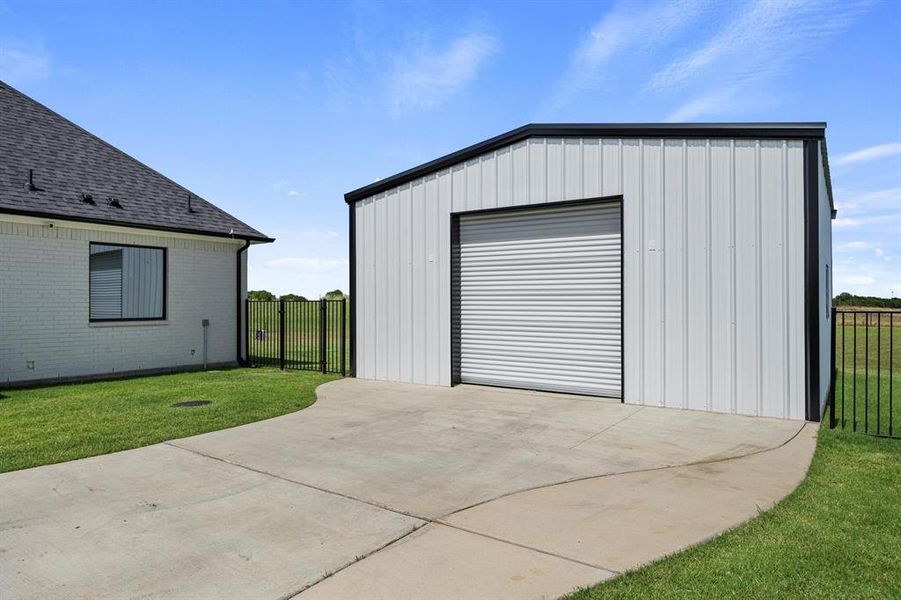 Detached garage featuring driveway Detached garage featuring driveway