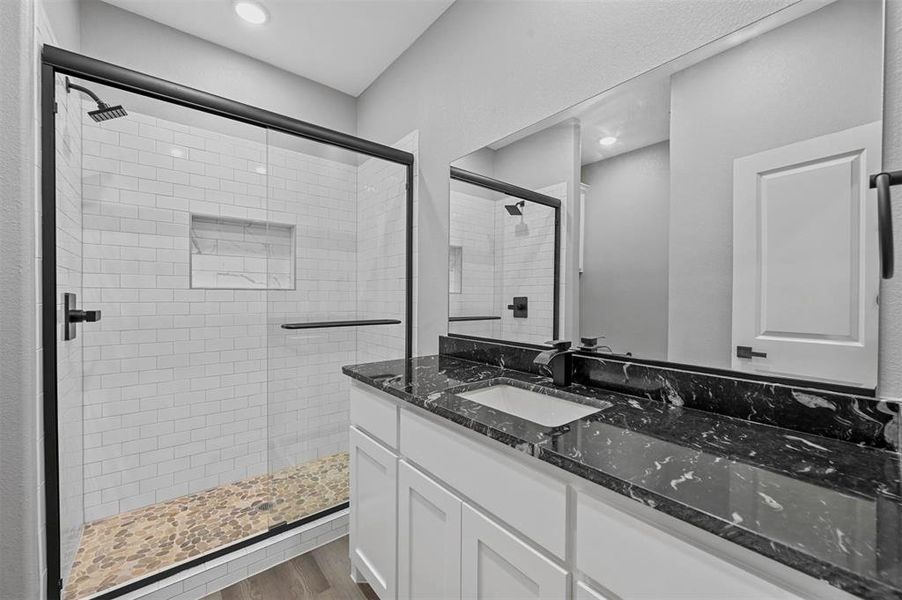 Bathroom with wood-type flooring, an enclosed shower, and vanity