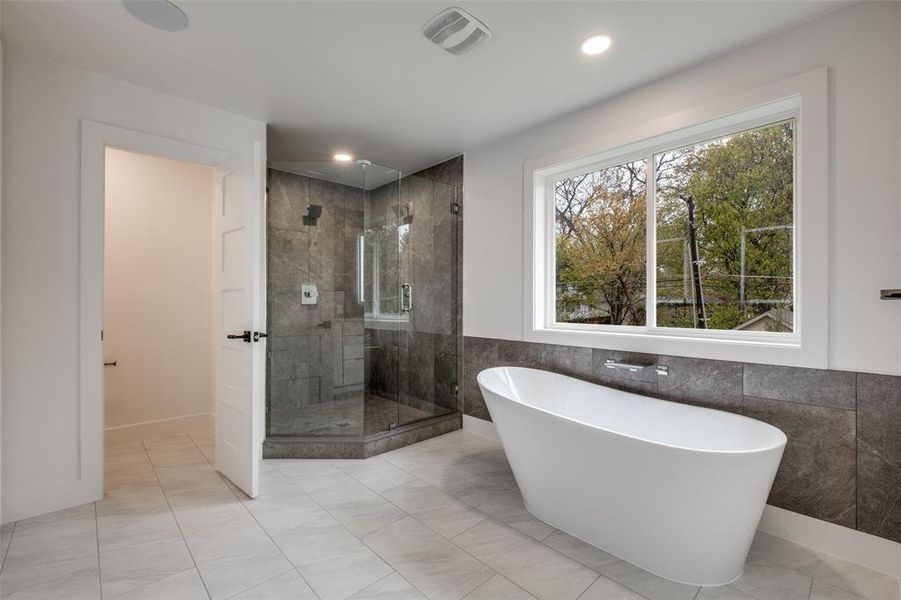 Bathroom with a freestanding bath, tile walls, a shower stall, wainscoting, and recessed lighting
