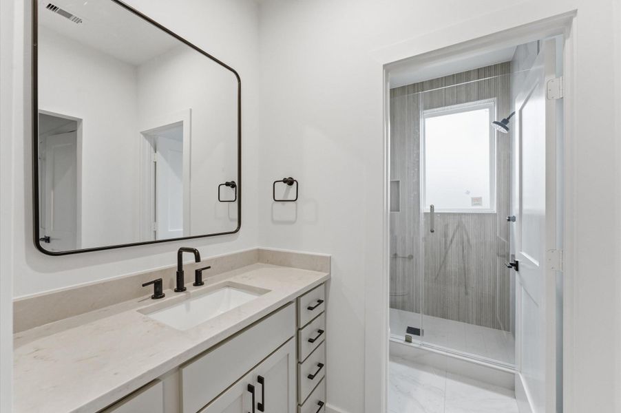 Secondary bathroom has quartz countertops and a privacy door for the shower area.
