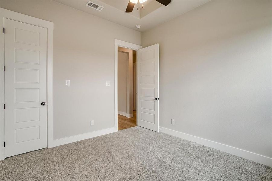 Carpeted empty room with ceiling fan