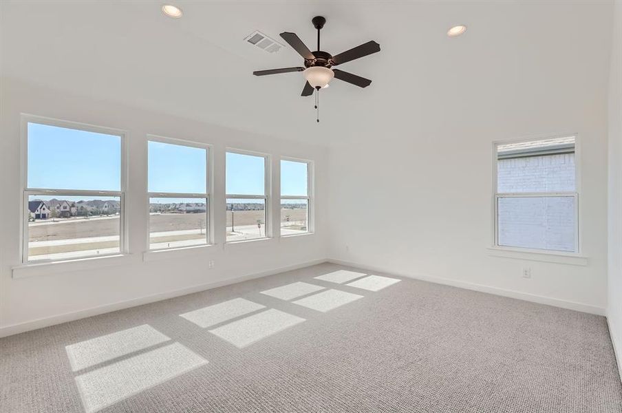 Carpeted spare room featuring ceiling fan