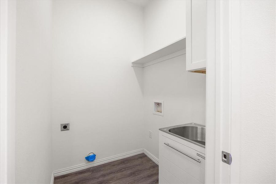 Clothes washing area featuring sink, cabinets, dark hardwood / wood-style floors, washer hookup, and hookup for an electric dryer