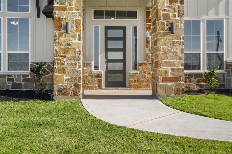 Guests will traverse the well-lit walkway and approach this sophisticated, 8ft wood door with sidelights and transom above. This grand entryway leaves a lasting first impression!