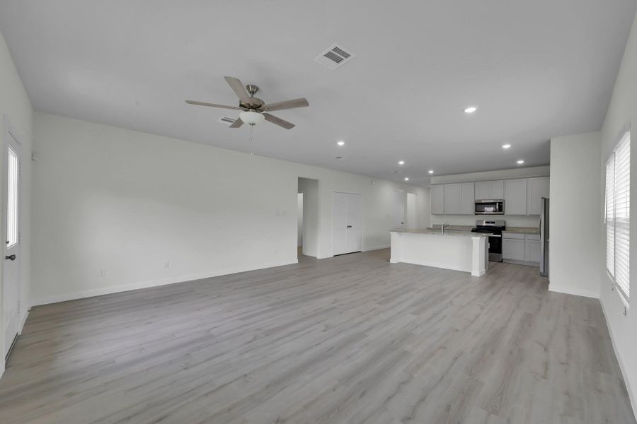 Open living space with seamless flow into the kitchen, enhanced by updated flooring and a versatile layout. Open living space with seamless flow into the kitchen, enhanced by updated flooring and a versatile layout.