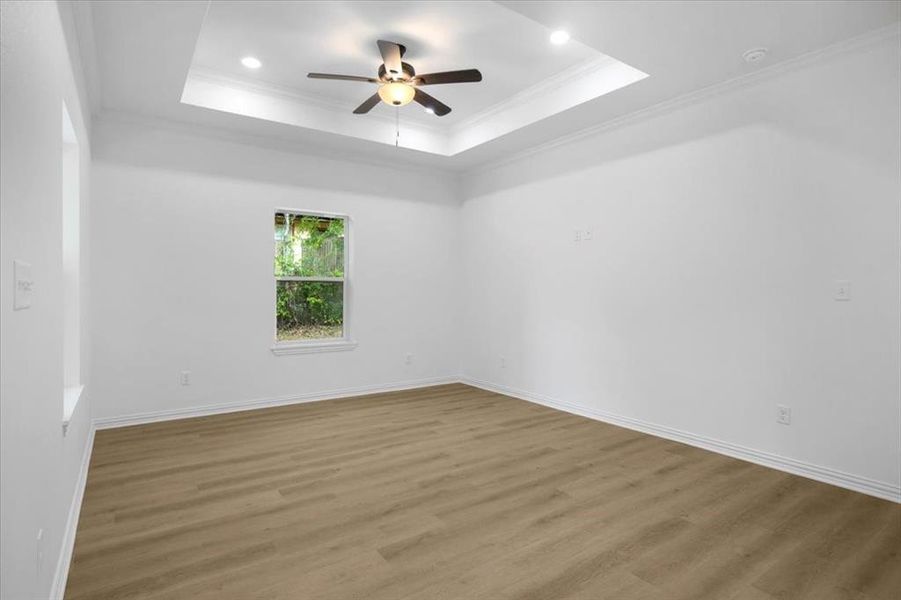 Empty room with ornamental molding, wood finished floors, a ceiling fan, and recessed lighting