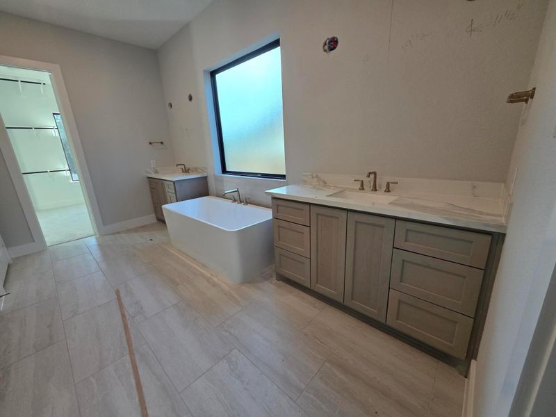 Primary suite bathroom with his and hers vanity.