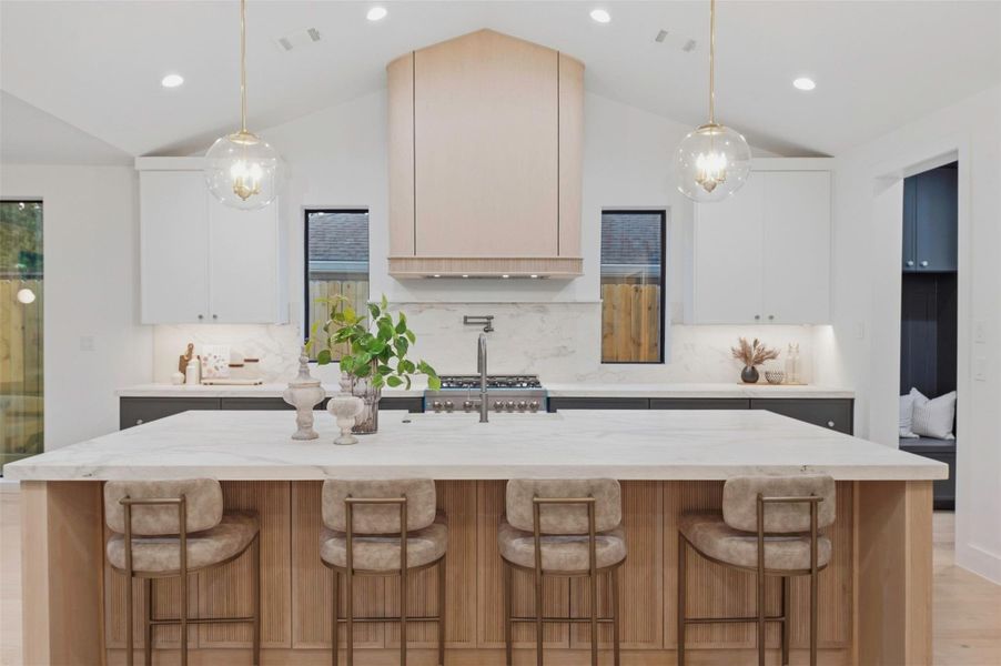 Designer kitchen features custom white oak cabinetry, premium finishes, and an oversized statement island.