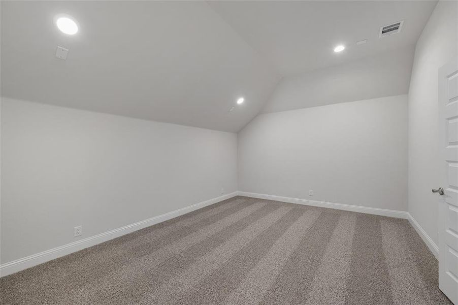 Additional living space featuring light colored carpet, lofted ceiling, and recessed lighting