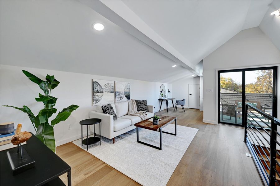 Living room with wood-type flooring and lofted ceiling