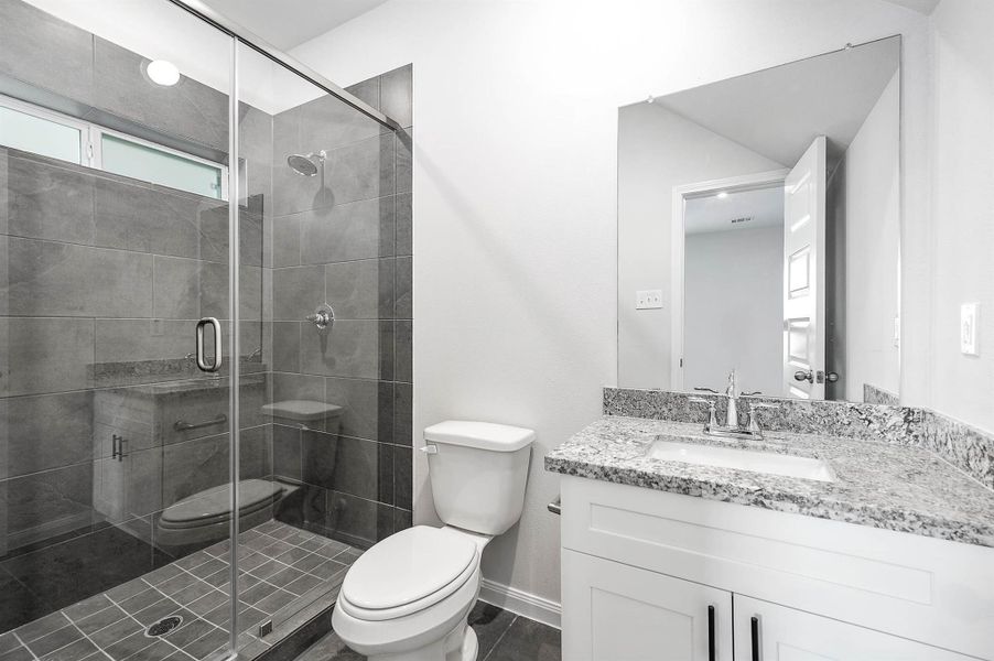 1st floor secondary bathroom, featuring modern vanity finishes and a glass enclosed shower. 1st floor secondary bathroom, featuring modern vanity finishes and a glass enclosed shower.