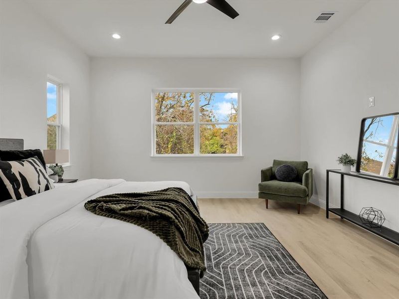 Bedroom featuring multiple windows, ceiling fan, and light hardwood / wood-style floors