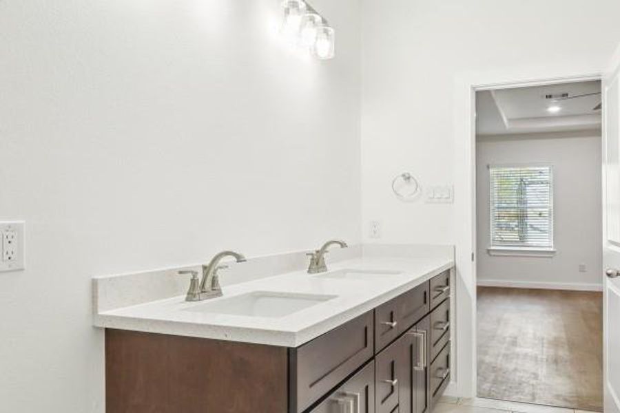 Experience luxury with a spacious dual-sink vanity in the primary bathroom. Experience luxury with a spacious dual-sink vanity in the primary bathroom.