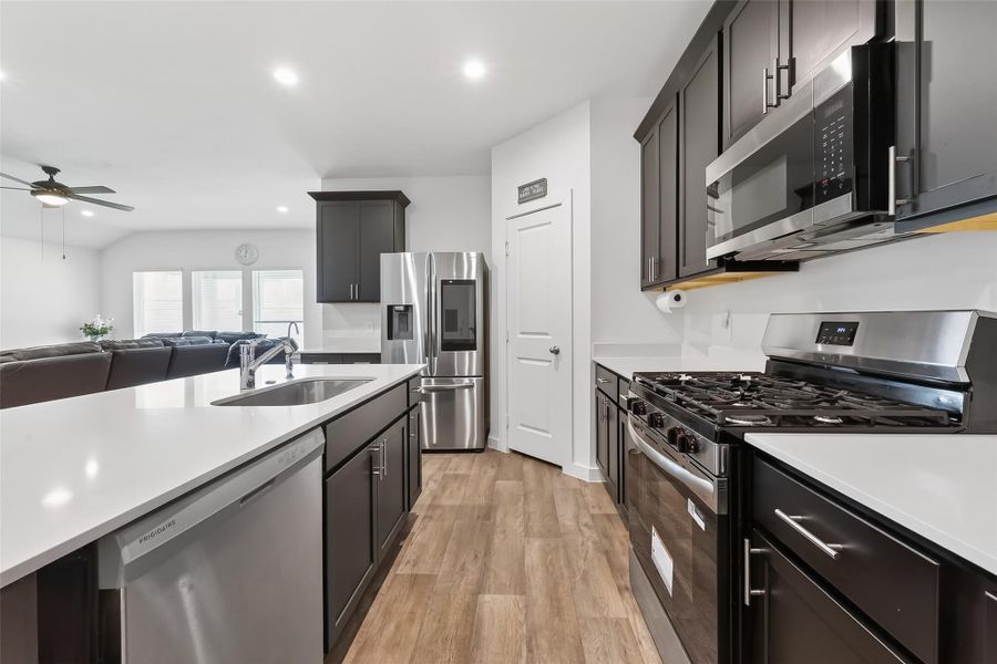 Gorgeous kitchen with quartz countertops, enhanced cabinetry with hardware, and refined crown molding accents