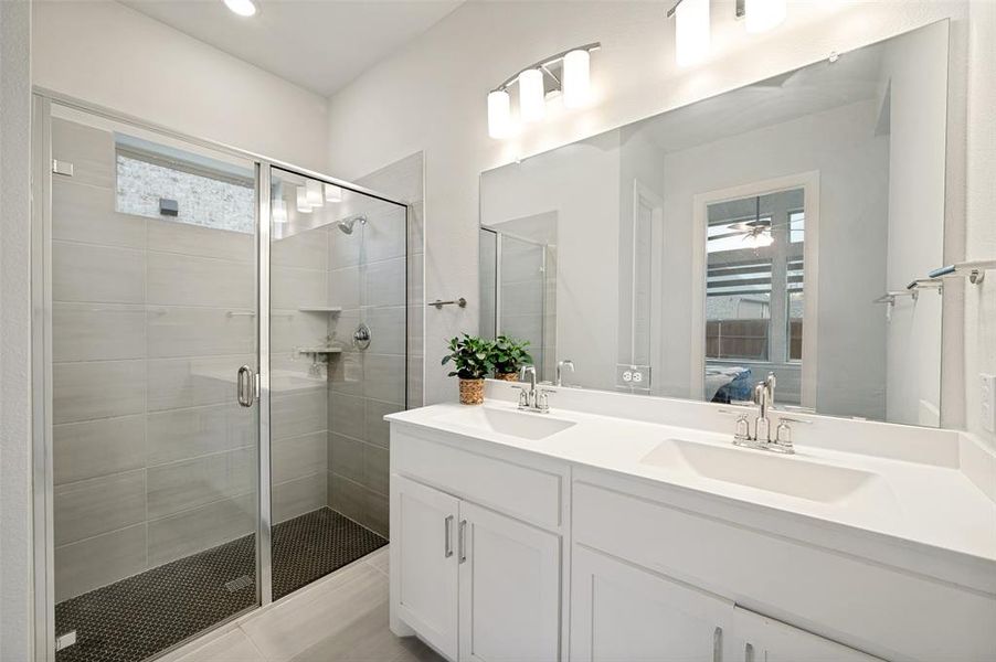 Dual vanity with integrated sinks, a large frameless mirror, and modern light fixtures