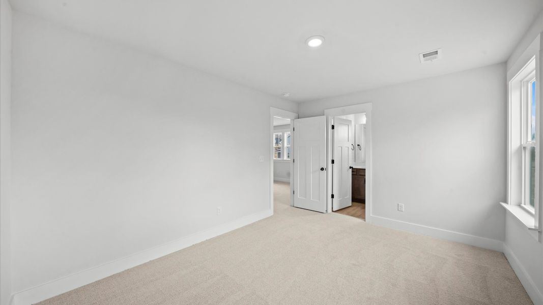 Superior comfort in this light-filled bedroom with plush carpeting and thoughtfully placed large windows