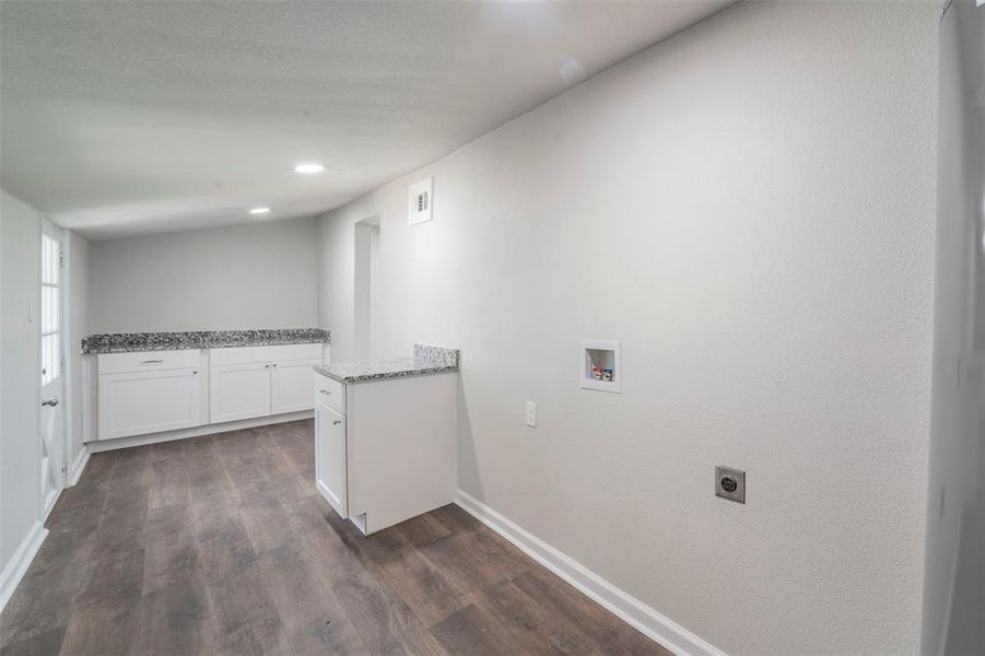 Laundry area with electric dryer hookup, cabinets, dark hardwood / wood-style flooring, and hookup for a washing machine