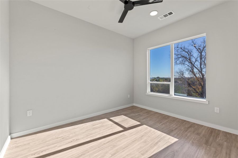 Spare room featuring ceiling fan and light hardwood / wood-style floors