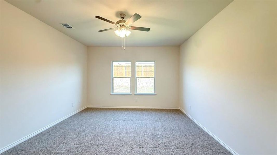 Carpeted empty room with baseboards and ceiling fan Carpeted empty room with baseboards and ceiling fan