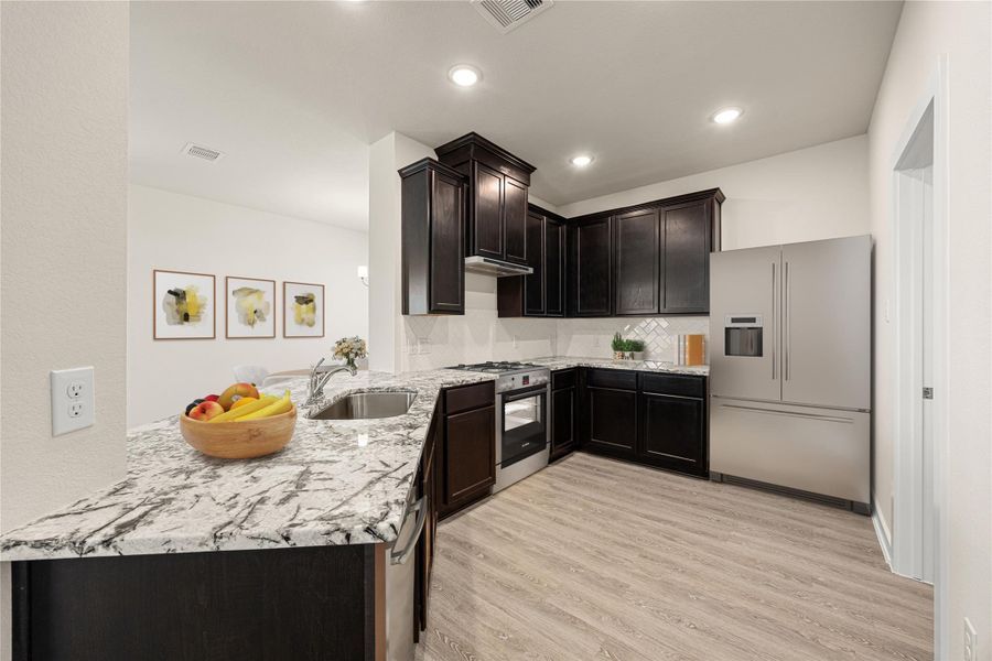 The kitchen features a modern design with stone countertops, stainless steel appliances, and a spacious island with pendant lighting. Its open layout connects seamlessly to the living area, creating a bright and inviting space. The kitchen features a modern design with stone countertops, stainless steel appliances, and a spacious island with pendant lighting. Its open layout connects seamlessly to the living area, creating a bright and inviting space.