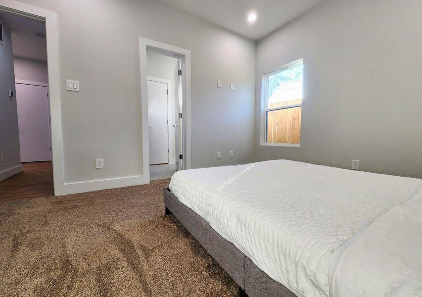 This cozy bedroom features soft carpet flooring, a window for natural light, and neutral walls. It has an attached bathroom and a door leading to a hallway, enhancing convenience and privacy. This cozy bedroom features soft carpet flooring, a window for natural light, and neutral walls. It has an attached bathroom and a door leading to a hallway, enhancing convenience and privacy.