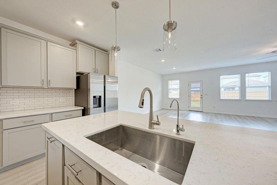Culinary delights await in this bright, open kitchen featuring a large island, sleek stainless steel appliances, and ample counter space.