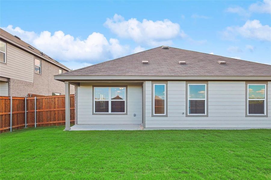 Back of property featuring a lawn and a patio