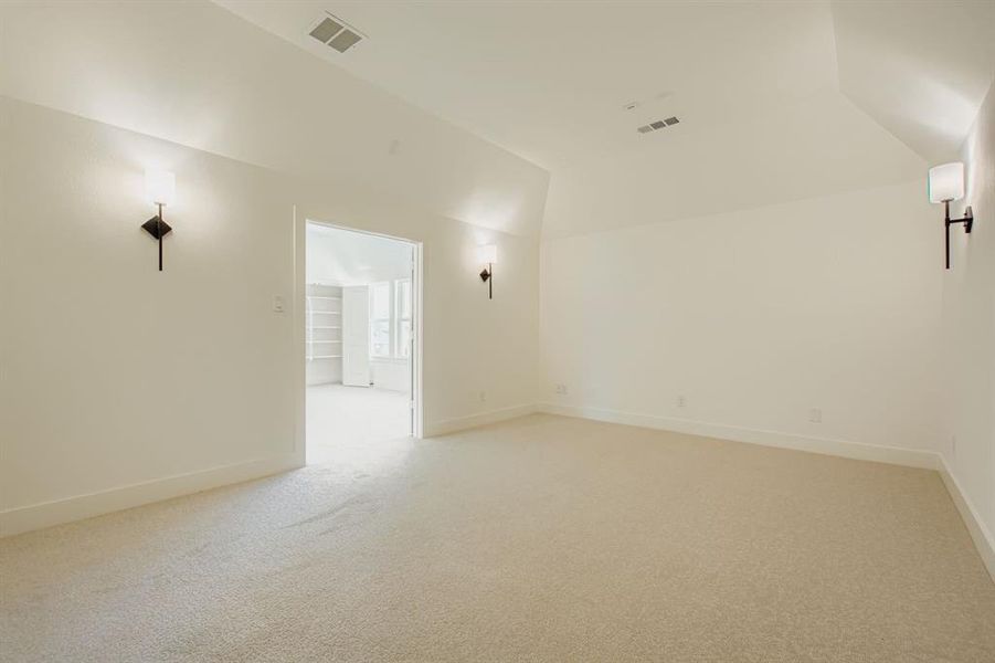 Spare room with light carpet and vaulted ceiling Spare room with light carpet and vaulted ceiling