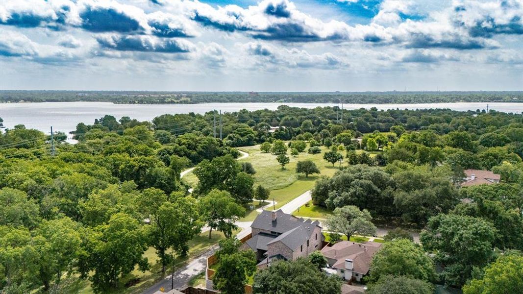 Expansive natural surroundings featuring a large body of water, abundant mature trees, and visible residential properties