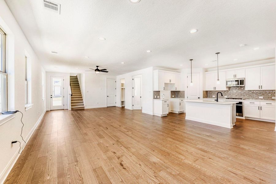 Unfurnished living room with light wood-type flooring, recessed lighting, and a ceiling fan Unfurnished living room with light wood-type flooring, recessed lighting, and a ceiling fan