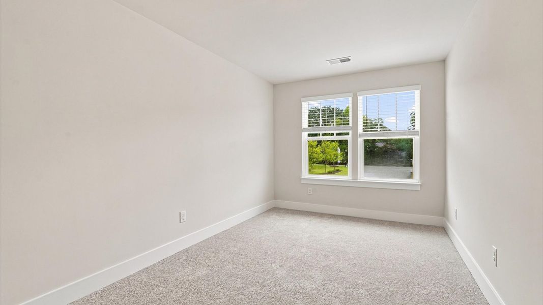 Bright and serene bedroom with comfortable carpeted flooring and large windows for vibrant light Bright and serene bedroom with comfortable carpeted flooring and large windows for vibrant light