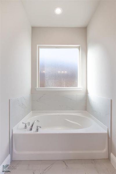 Full bathroom featuring a bath, light marble finish flooring, and recessed lighting