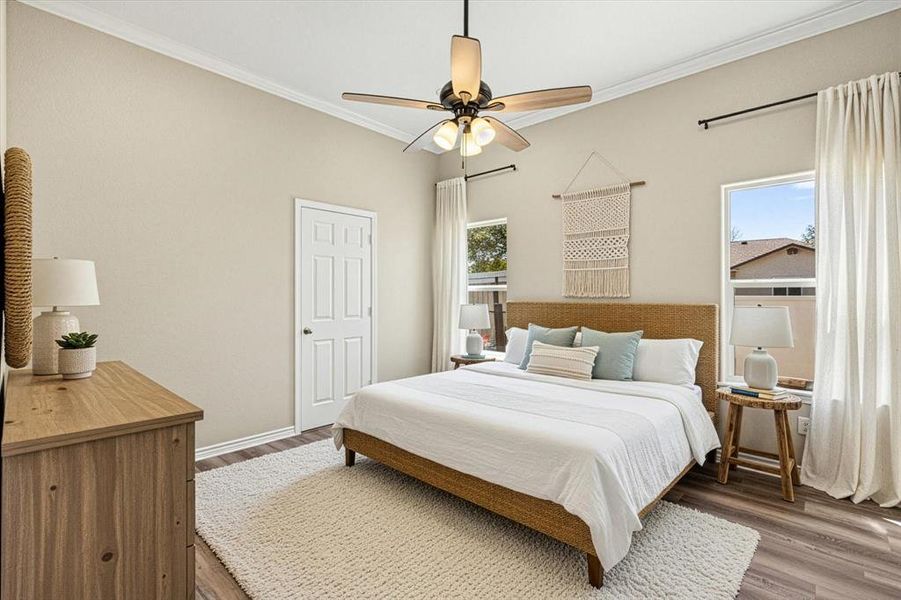 Bedroom with crown molding, a ceiling fan, and wood finished floors