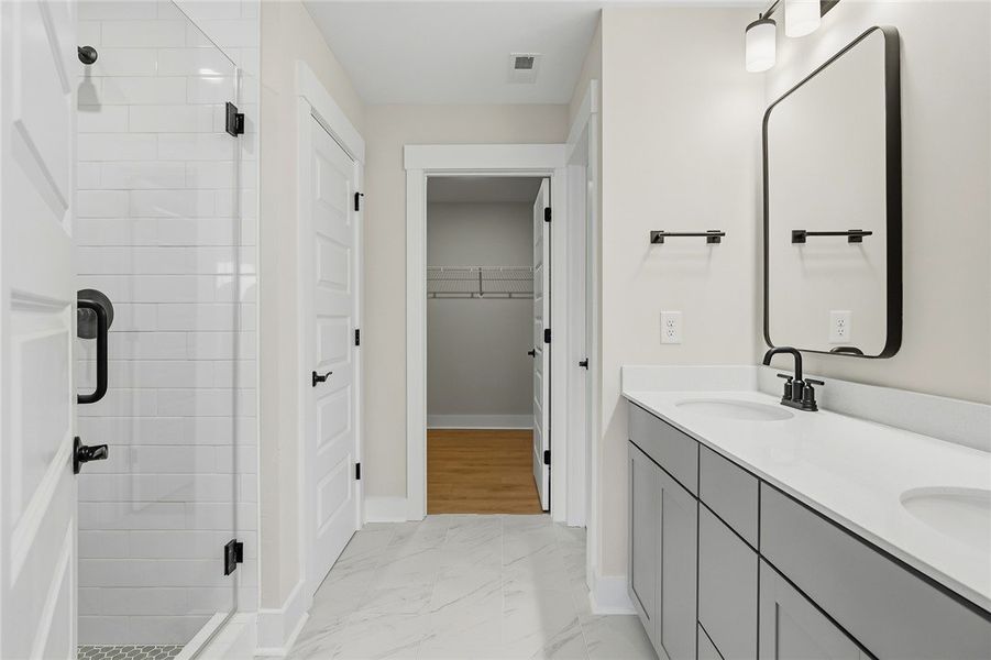 Gleaming stone tile flooring and a double vanity d