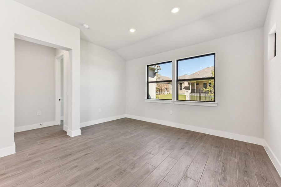 Empty room featuring recessed lighting, light wood finished floors, and vaulted ceiling Empty room featuring recessed lighting, light wood finished floors, and vaulted ceiling