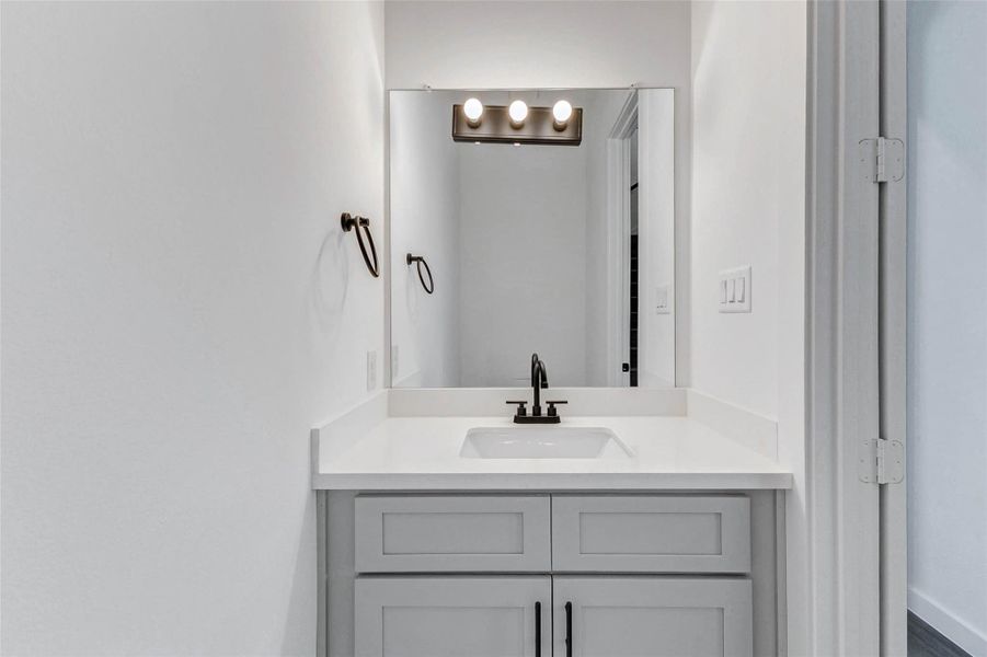 Clean and contemporary, this full bath showcases a single-sink vanity with shaker-style cabinetry, black matte fixtures, and stylish wall lighting—perfect for daily routines or guest use. Clean and contemporary, this full bath showcases a single-sink vanity with shaker-style cabinetry, black matte fixtures, and stylish wall lighting—perfect for daily routines or guest use.