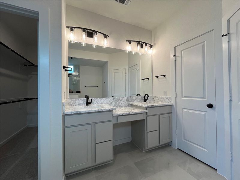 The bathroom includes a double sink with elegant marble countertops.