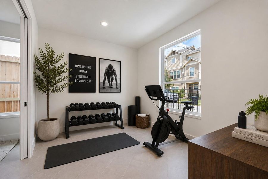 A flex room found on the first floor perfect for fitness room that could also serve as a home office, playroom and more. A digitally staged image.