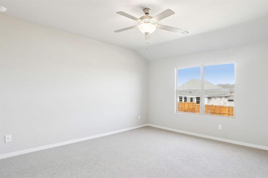 Spare room with carpet, vaulted ceiling, and ceiling fan Spare room with carpet, vaulted ceiling, and ceiling fan