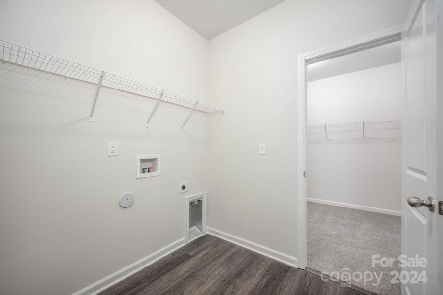 Laundry room with access to primary closet and hall