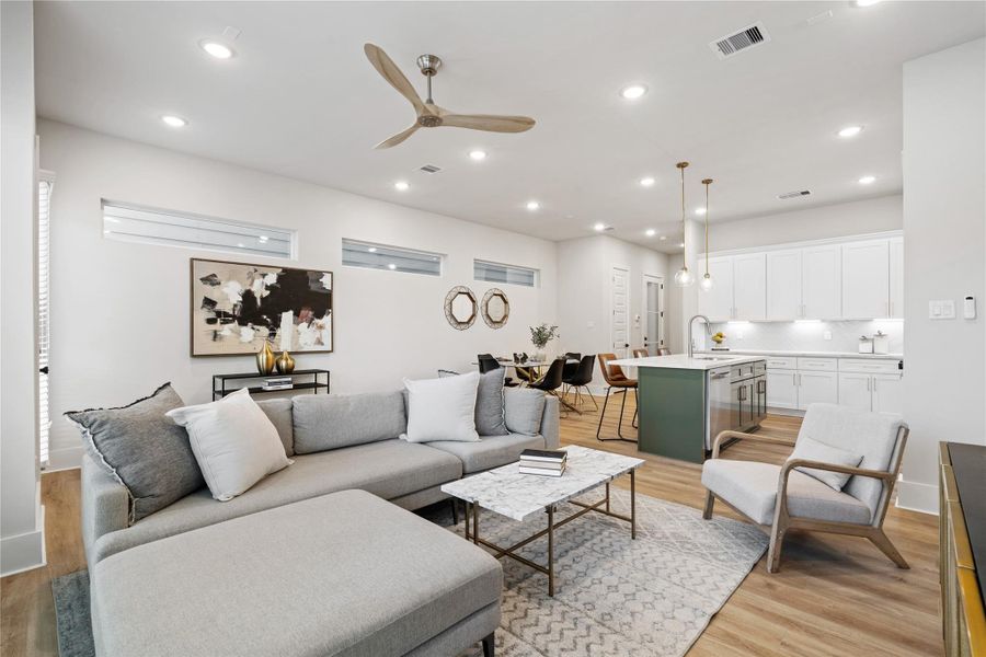 Volume and light define the main living space, where elevated ceilings and expansive windows enhance the open layout. A dedicated dining area introduces structure, creating a balanced flow between gathering and everyday living.