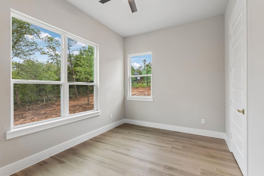 Two large windows provide ample illumination and woodland views to this flexible room.