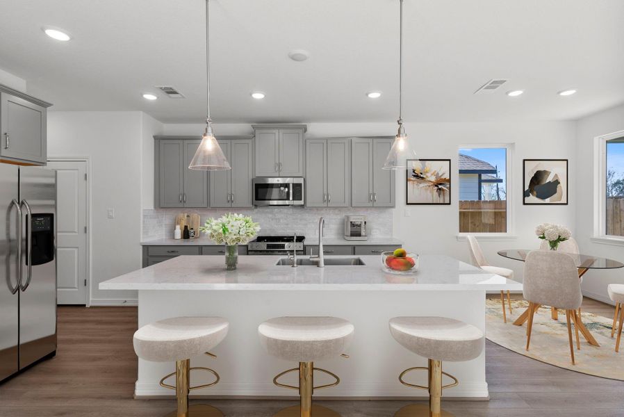 A chef’s dream kitchen featuring a large island, statement pendant lighting, and an open-concept layout—perfect for entertaining and everyday living