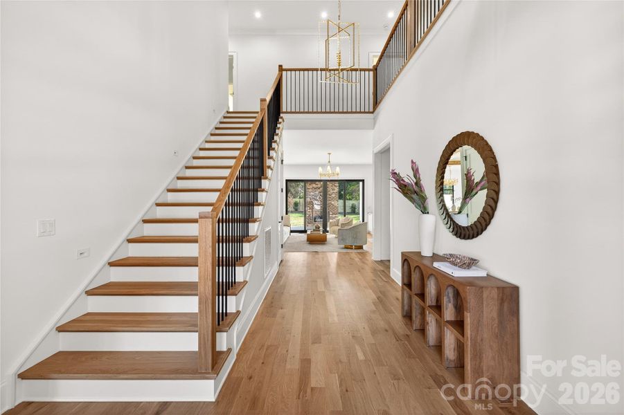 Entry Hall with gorgeous banister. Floors are beautiful. Lighting, too! Very welcoming!