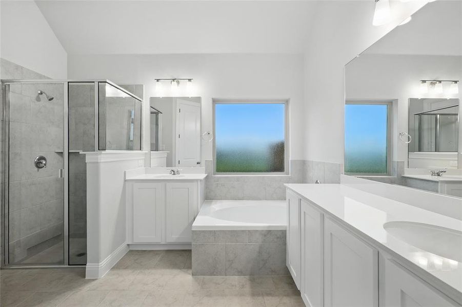 Full bath featuring a stall shower, two vanities, and a bath Full bath featuring a stall shower, two vanities, and a bath