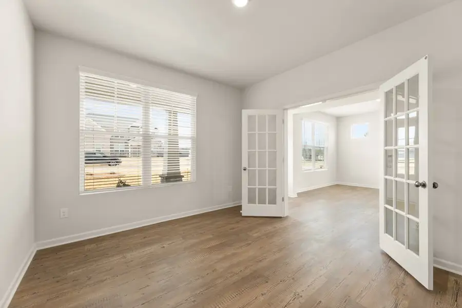 A room with a wood floor and a window with a view of the water. A room with a wood floor and a window with a view of the water.